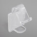 A close up of a Snap Drape clear plastic table skirt clip with hook and loop attachment.