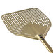 A close-up of a GI Metal gold anodized aluminum square perforated pizza peel with a long metal handle and a square perforated metal surface.