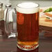A Libbey glass mug of beer on a table.