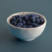 A Elite Global Solutions Chocolate Chip round melamine bowl filled with blueberries on a table.