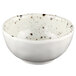 A white Elite Global Solutions round melamine bowl with black speckled spots.