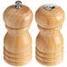 A wooden salt shaker and pepper mill set with metal lids.