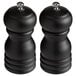 Two Acopa matte black wooden salt and pepper mills on a white counter.