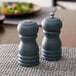 A wooden salt shaker and pepper mill set on a table.