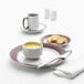 A Libbey Lunar Bright white porcelain bowl with a solid band of apple butter on a plate with a bowl of soup and a spoon.
