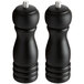 Two black matte wooden salt and pepper mills with silver tops.