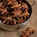 A metal bowl filled with Regal Whole Star Anise.