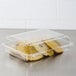 A Dart clear plastic oblong container with cookies inside.