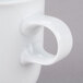 A close-up of a 10 Strawberry Street Taverno white porcelain coffee mug with a handle.
