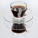 A Libbey glass cappuccino cup filled with coffee on a white saucer.