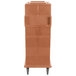 A brown plastic Cambro Ultra Camcart for food pans on wheels.