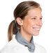 A woman wearing a white chef's coat and a grey Intedge chef's neckerchief.