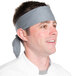 A man wearing a gray chef neckerchief and a chef hat.