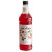 A close up of a Monin Premium Red Passion Fruit flavoring syrup bottle full of red liquid.