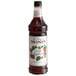 A Monin Premium Wild Raspberry Flavoring Syrup bottle with a label.