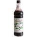 A Monin Premium Wild Blackberry Flavoring Syrup bottle filled with black liquid.