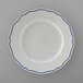 A Tuxton white china plate with scalloped edges and blue trim.