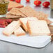 A cheese board with Walnut Creek Foods Smoked Hot Pepper Cheese, crackers, and food.
