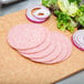 Sliced Taylor pork roll and onions on a cutting board.