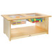 A wooden Whitney Brothers toddler sensory table with plastic bins and toys inside.
