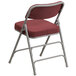 A burgundy Flash Furniture folding chair with metal legs.