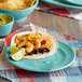 A Tuxton Concentrix Island Blue china plate with shrimp tacos, black beans, and guacamole.