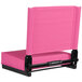 A pink folding stadium chair with a black frame.