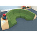 A Whitney Brothers Five Section Reading Nook with a green cushion and a stuffed bear reading a book.