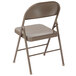 A beige metal folding chair with a backrest.