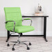 A green Flash Furniture mid-back office chair with chrome legs in front of a black desk.