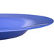 A close-up of a Carlisle Ocean Blue melamine chef bowl with a curved edge.