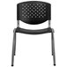 A black plastic Flash Furniture stack chair with a grey and silver frame and holes in the back.