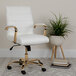 A white Flash Furniture office chair with gold legs and arms next to a potted plant.
