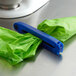 A blue Twixit! pastry bag clip on a green plastic bag on a counter.