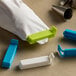 A bag of pastry bag clips with green and blue plastic holders.