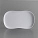 A white Carlisle Stadia melamine platter with a curved edge on a gray surface.