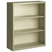 A Hirsh putty steel bookcase with three shelves.