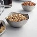 An American Metalcraft stainless steel bowl filled with nuts on a table.