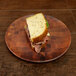 A sandwich with meat and lettuce on an Elite Global Solutions checkered bamboo melamine plate.