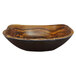 A wood grain rectangular melamine serving bowl with a curved edge.