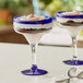 A dessert in an Acopa margarita glass with a blue rim and base.