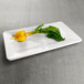 A white rectangular Elite Global Solutions melamine tray with a radish on it.