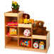 A Whitney Brothers wooden pyramid storage shelf with toys and a plant.