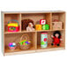 A Whitney Brothers wooden storage cabinet with five compartments holding toys and other objects.