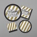 A group of Creative Converting black beverage napkins with gold and black stripes.