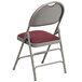 A Flash Furniture burgundy metal folding chair with a padded fabric seat.