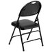 A Flash Furniture black metal folding chair with black padded vinyl seat.