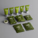 A collection of green Noble Eco Novo Terra hotel amenity packages with white text and a green package of soap.