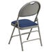 A navy blue metal folding chair with a padded blue seat.