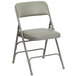 A gray metal folding chair with a padded gray seat.